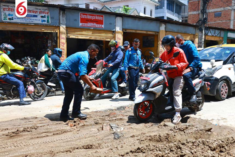 काठमाडौँमा विद्युत प्राधिकरणले खनेका खाल्डा पुर्दै ट्राफिक प्रहरी(तस्बिरहरु)